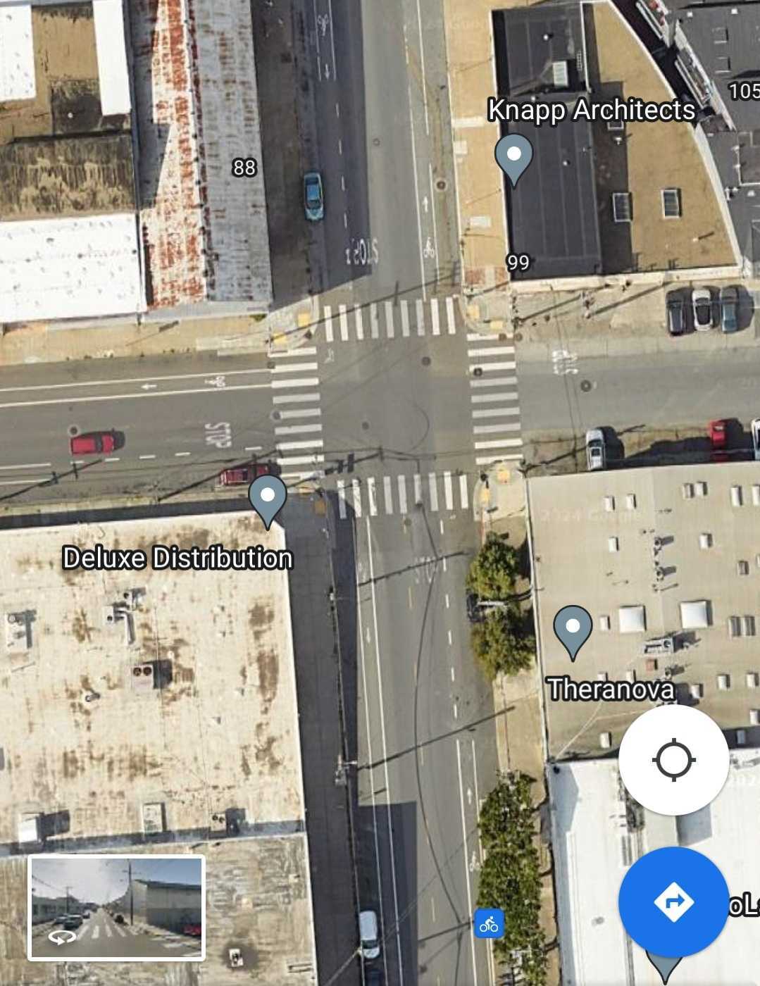Screenshot of Google Maps satellite view of the intersection of 17th St and Mississippi St in San Francisco. There are wide painted crosswalks, and paint-only bike lanes on three sides of the intersection. The bike lanes have dashed lane markers on the approach sides, indicating that drivers turning right should cross into the bike lane. Though there are few cars in the image, it appears that all of the bike lanes have parking between the bike lane and the sidewalk, meaning drivers must cross the bike lane to park.