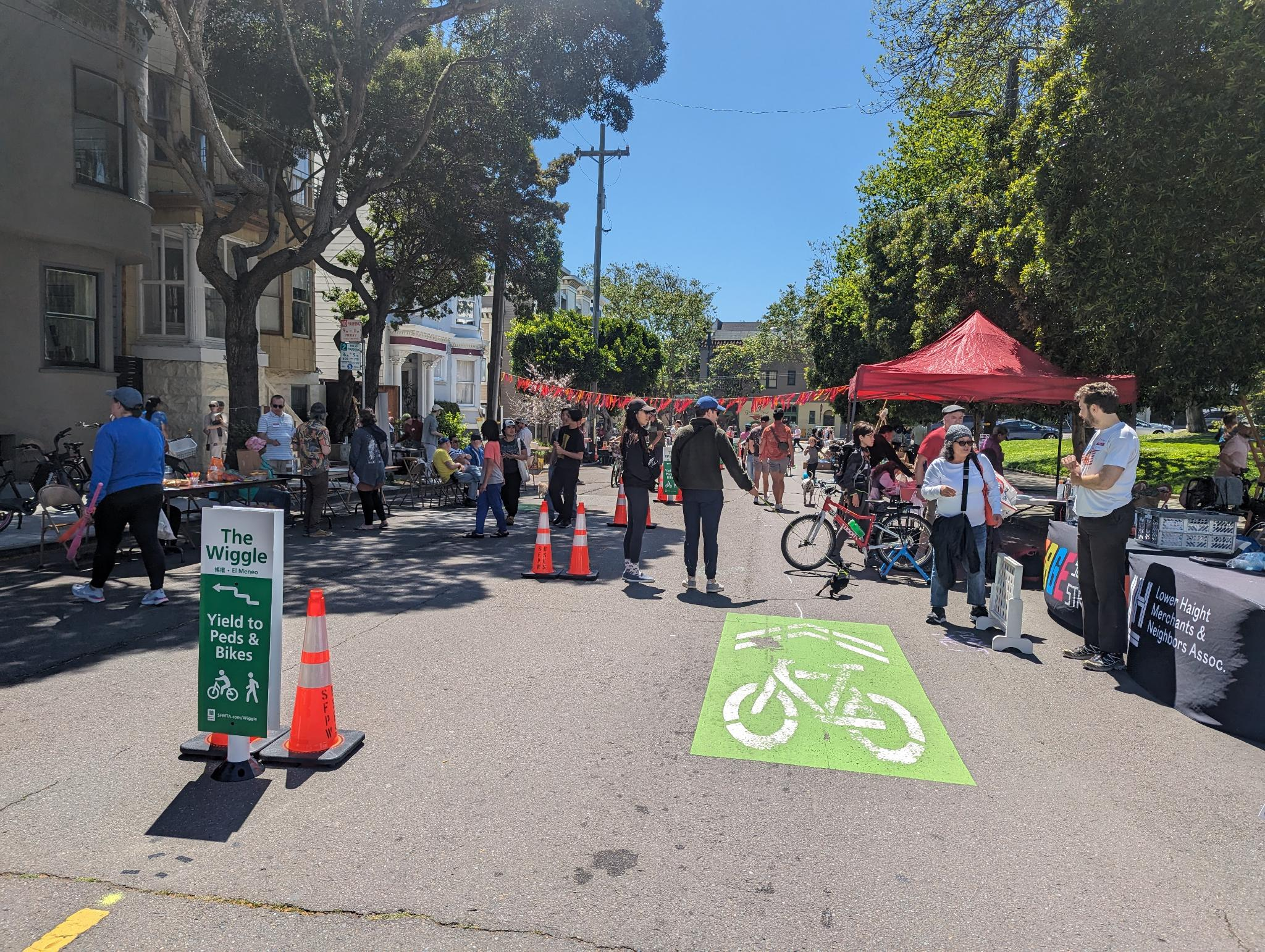 People at a block party in the street with the Wiggle signs