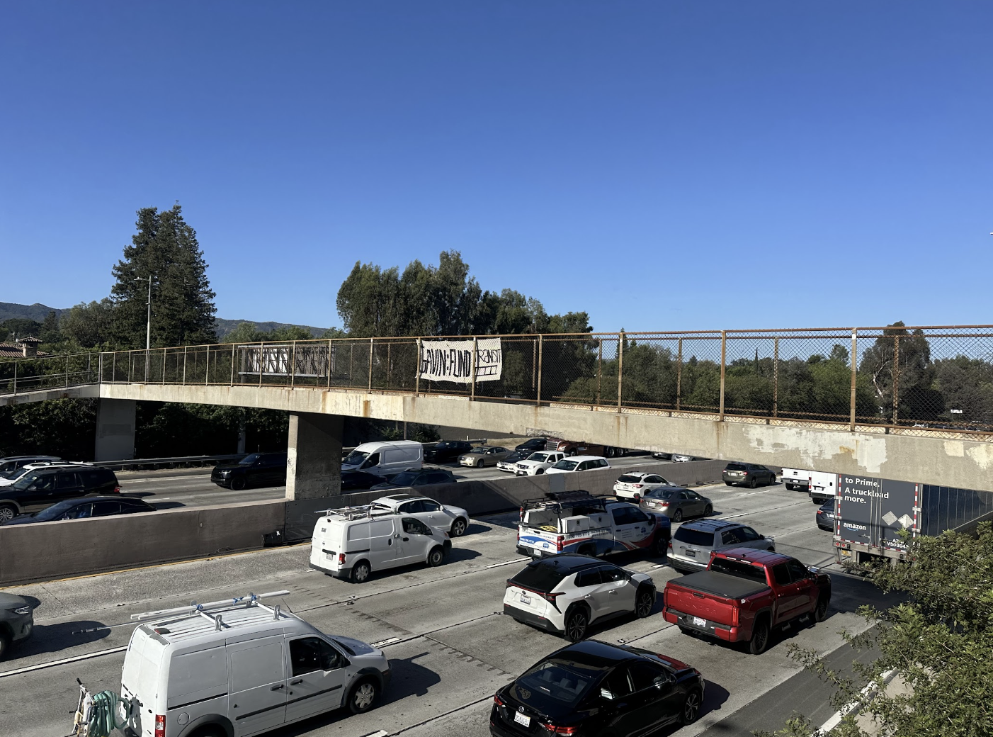 Banner hung above a freeway in the San Fernando Valley on a pedestrian overpass reading "Gavin: Fund Transit"